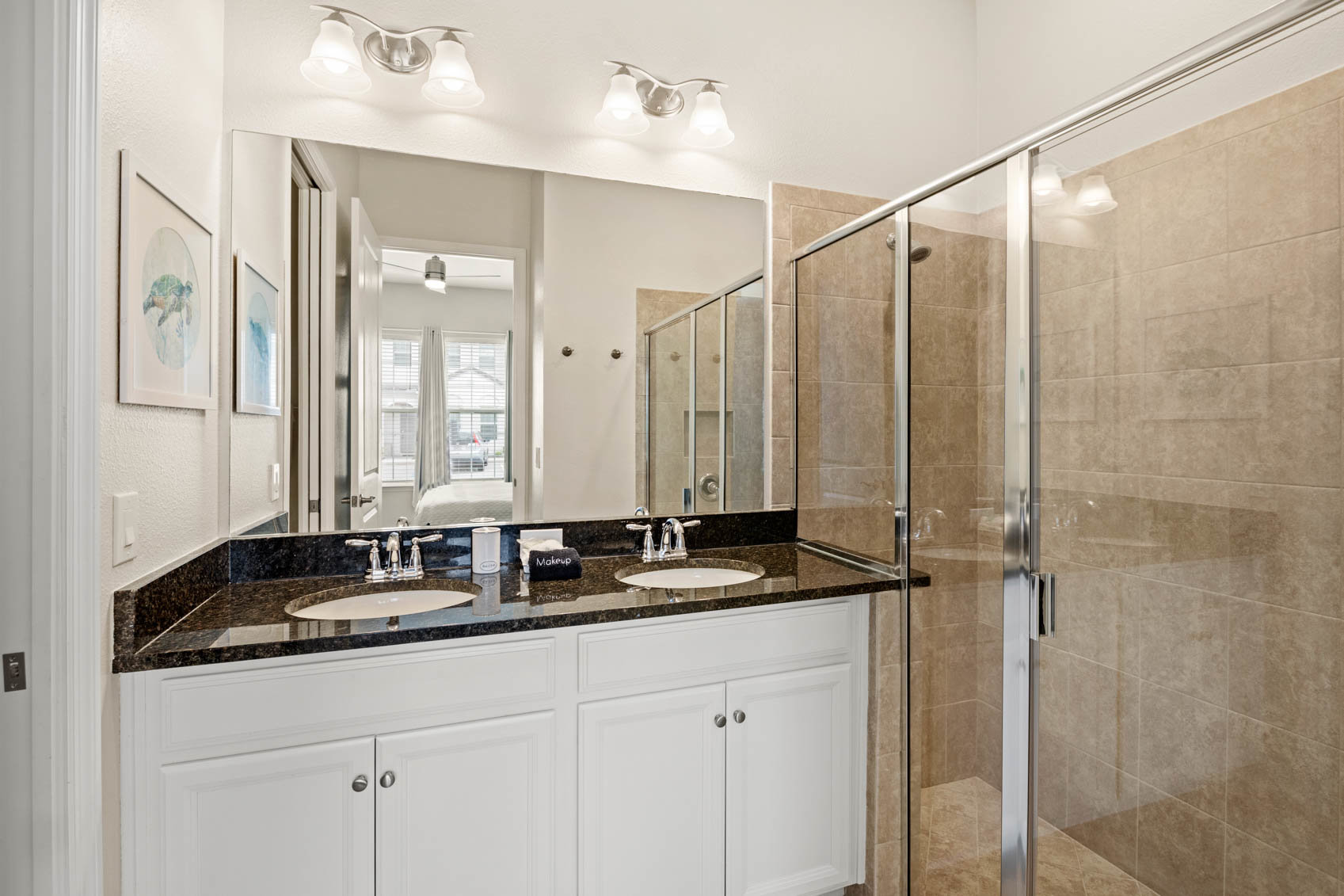 bathroom with dark marble counter and double sinks